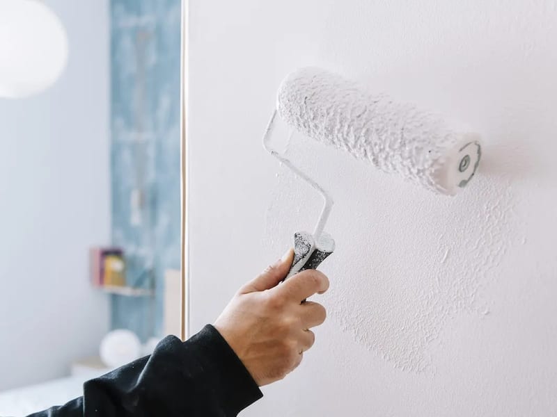 Painter rolling a wall with a paint roller